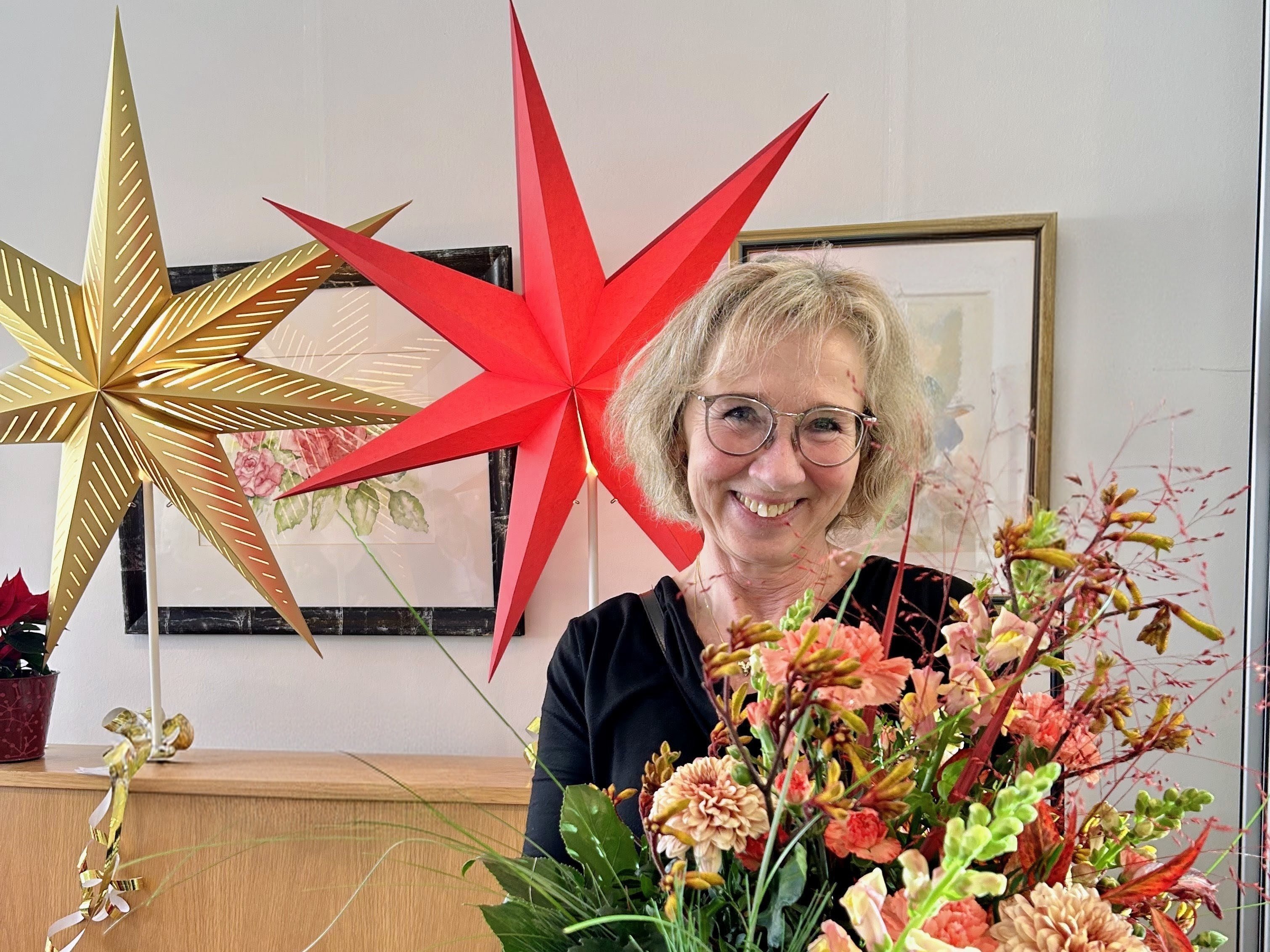 Zeit für Neues – Bärbel Maas verabschiedet sich in den Ruhestand. Sie hält einen großen Blumenstrauß in den Händen und lächelt fröhlich.